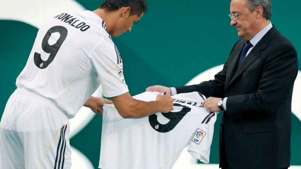 Cristiano Ronaldo firma una camiseta junto a Florentino Pérez en el día de su presentación con el Real Madrid.