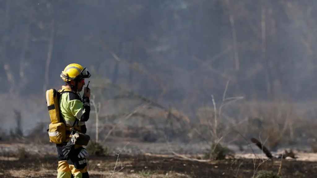 Un bombero trabaja en una zona afectada por un incendio forestal declarado en Riba-roja de Túria (Valencia)