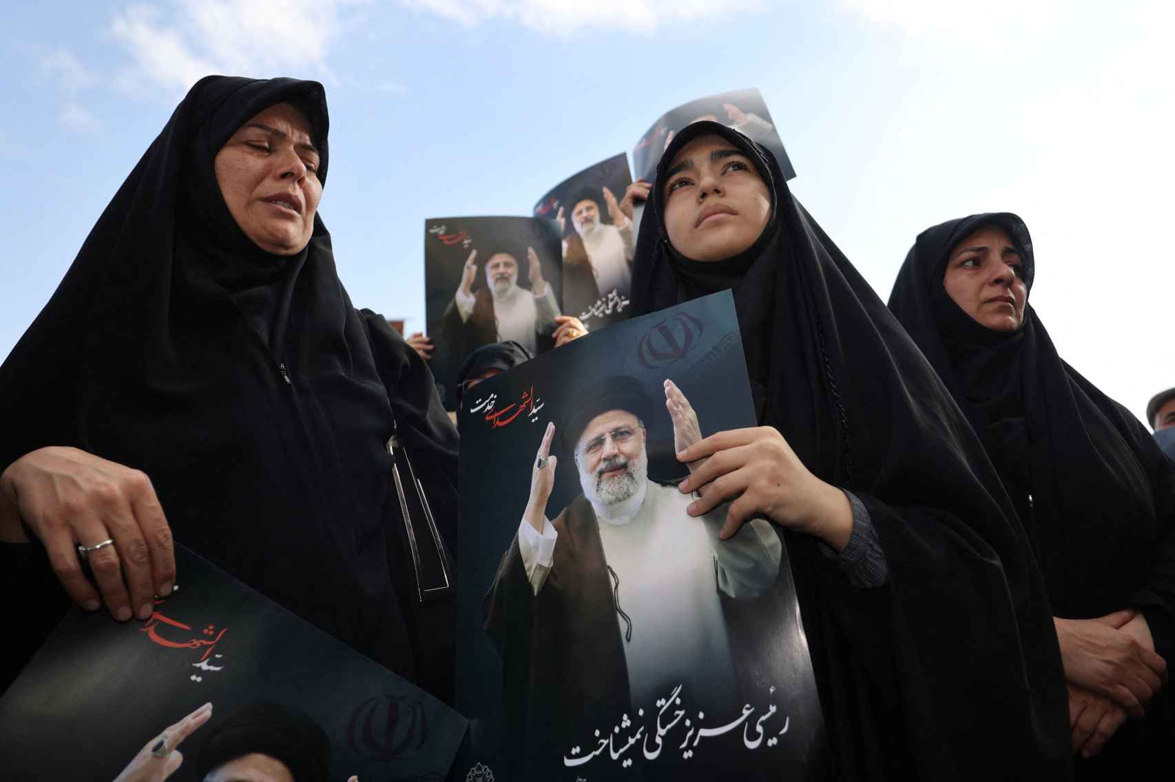 Varias mujeres lloran la muerte de Raisi en Teherán.
