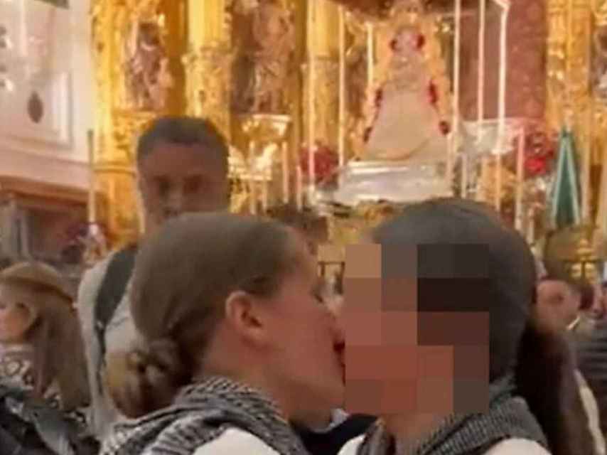 Dos chicas se besan frente a la Virgen del Rocío.