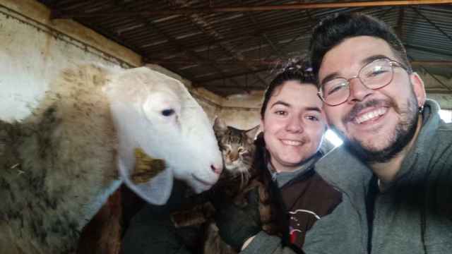 Andrea y Rodrigo en la nave familiar posan con una de las ovejas de su rebaño