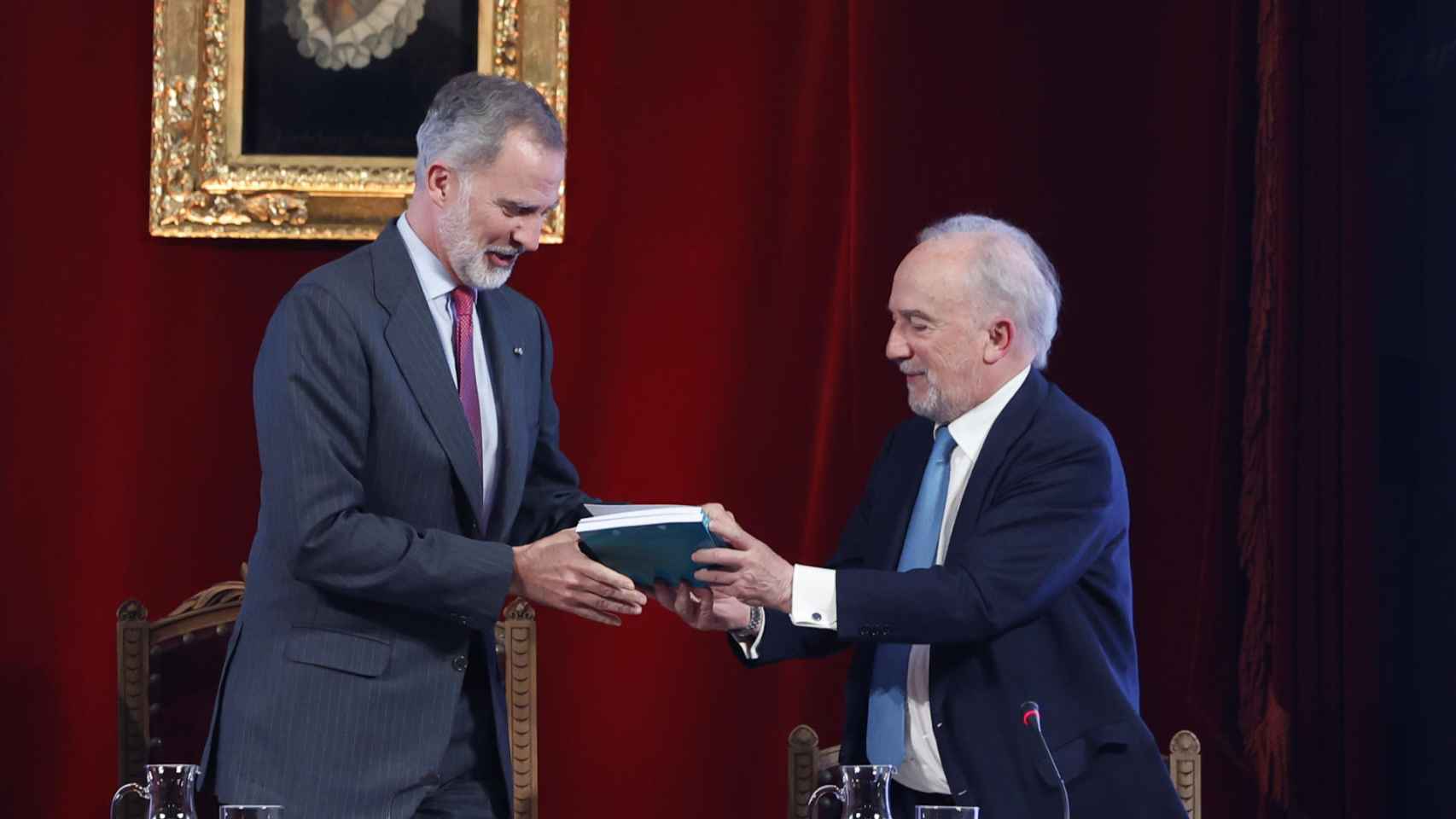 El director de la RAE, Santiago Muñoz Machado, entrega dos ejemplares de la 'Guía panhispánica de lenguaje claro y accesible' al rey Felipe VI, este martes en la sede de la RAE. Foto: EFE/Mariscal