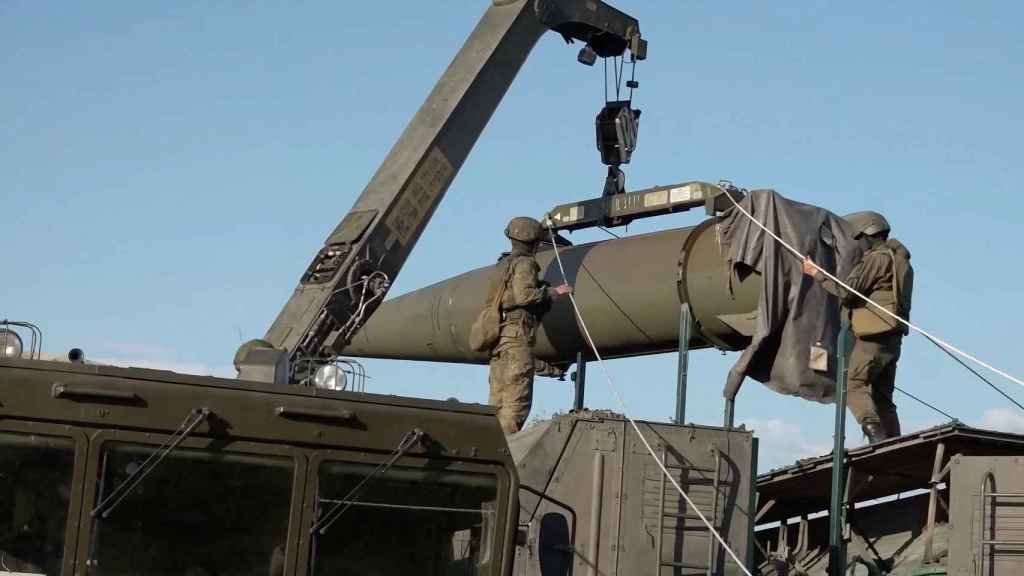 Personal militar ruso integrando un misil Iskander en un vehículo lanzador