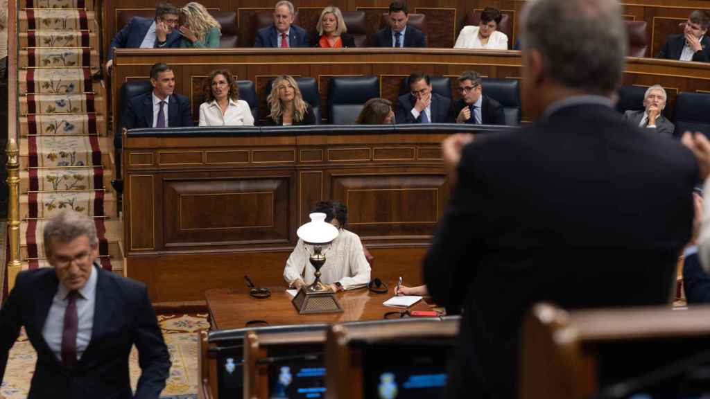 El presidente del PP, Alberto Núñez Feijóo, es aplaudido tras su intervención. Al fondo, el presidente del Gobierno, Pedro Sánchez, y la bancada azul del Gobierno.