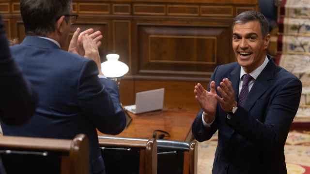 Pedro Sánchez, presidente del Gobierno, se aplaude mutuamente con Patxi López, portavoz del PSOE, en el Congreso.