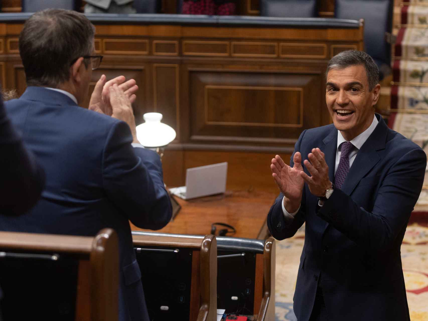 Pedro Sánchez, presidente del Gobierno, se aplaude mutuamente con Patxi López, portavoz del PSOE, en el Congreso.