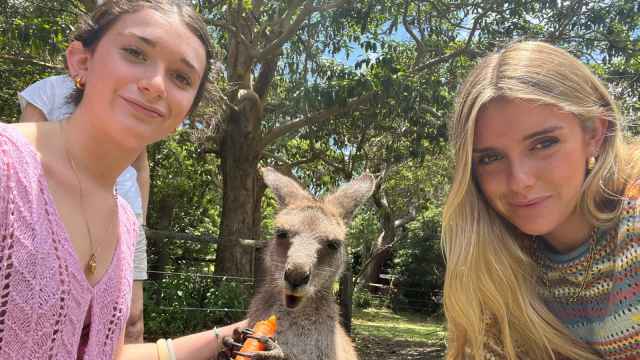 Paula junto a una amiga dando de comer a un canguro en Sídney.