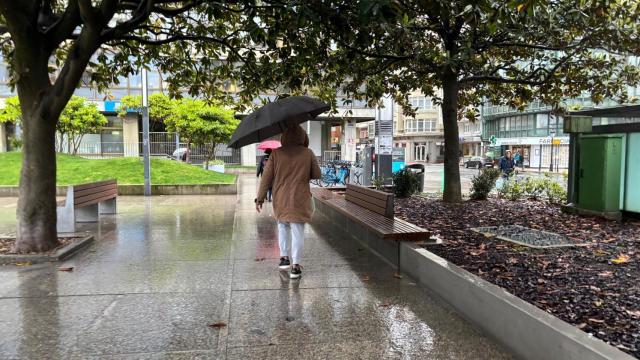 Una persona con paraguas en la Plaza de Pontevedra