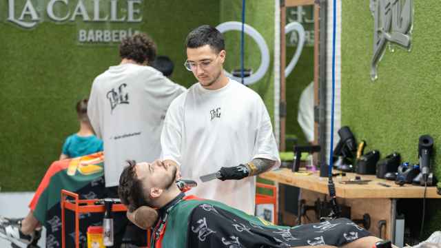 Francis De la Calle, atiende a sus clientes en la barbería que lleva su nombre.