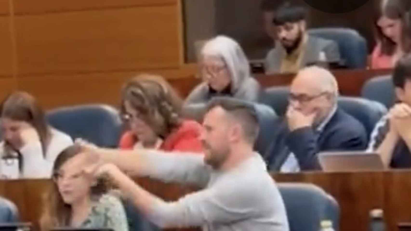 El diputado de Más Madrid Pablo Padilla realiza el gesto de disparar a Ayuso en la Asamblea.