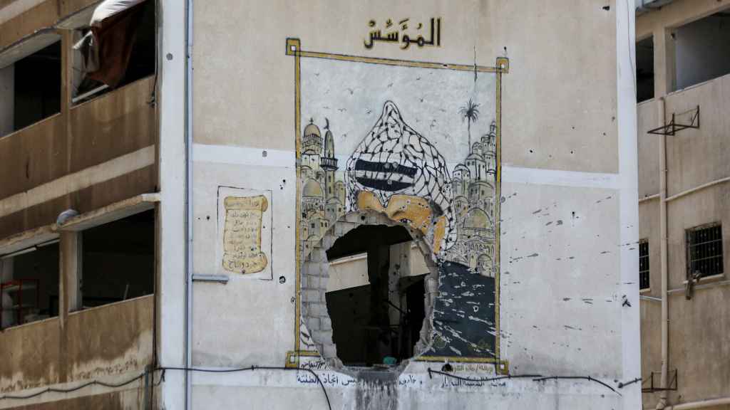 Un mural dañado del difunto presidente palestino Yasser Arafat en la Universidad al-Azhar de Gaza.