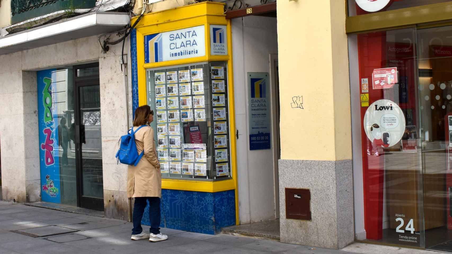 Una joven busca vivienda en una inmobiliaria.