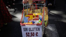Una persona exhibe un 'carrito protesta' por los altos precios de los productos sin gluten.