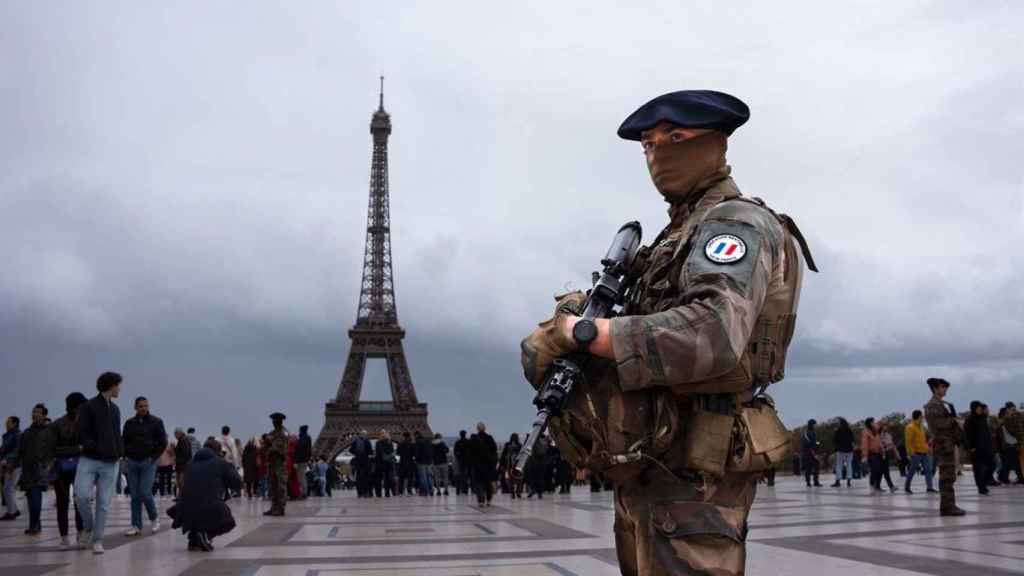 Un militar porta su arma enfrente de la Torre Eiffel en Paris, Francia.