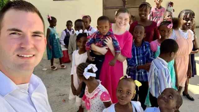 Los misioneros estadounidenses Davy y Natalie Lloyd posan en un 'selfie' con un grupo de niños haitianos.