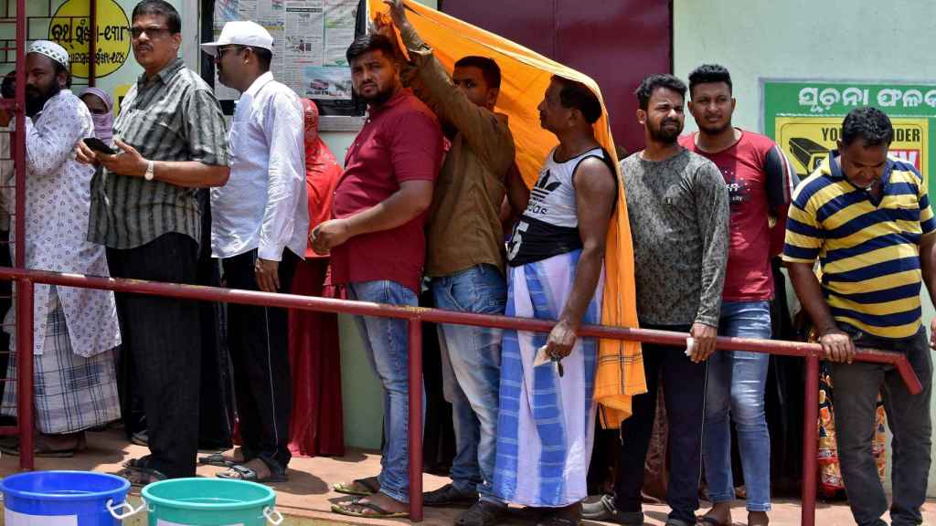 Ciudadanos indios hacen cola para votar en plena ola de calor.