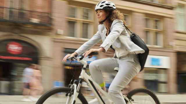 Imagen de archivo de una mujer en bicicleta en la ciudad.