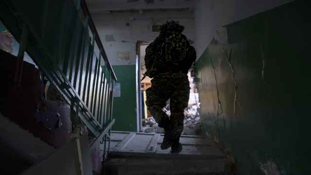 Un soldado de la Legión Internacional inspecciona uno de los edificios bombardeados en el frente Lyman-Kupyansk.