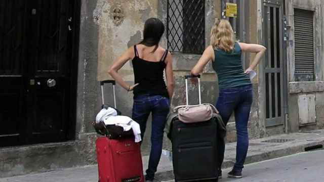 Dos turistas esperan para entrar en un apartamento vacacional