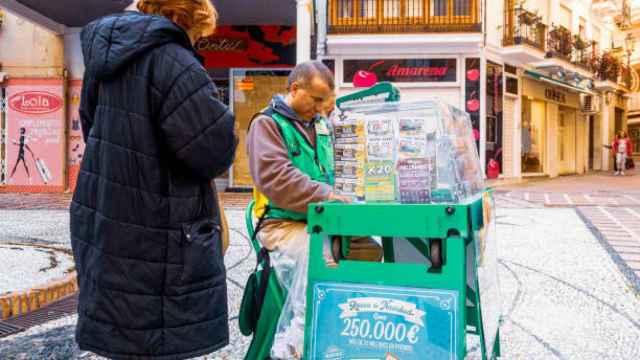 Un comercial de la ONCE vendiendo cupones en un kiosko.