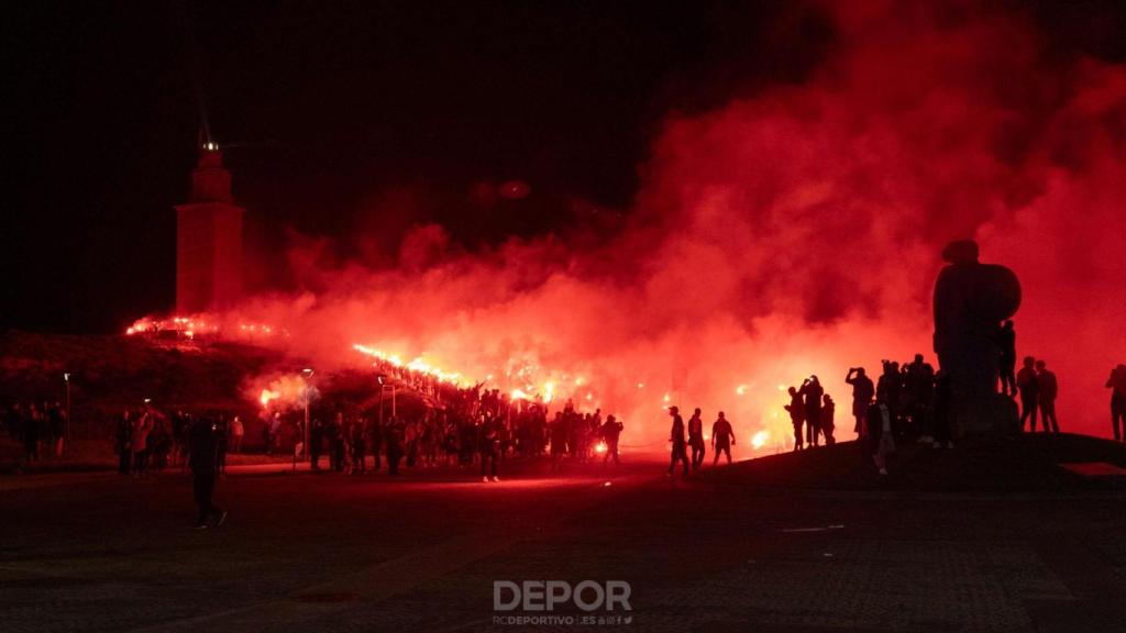 Decenas de bengalas tiñen de rojo la Torre de Hércules de A Coruña por la fiesta del Dépor