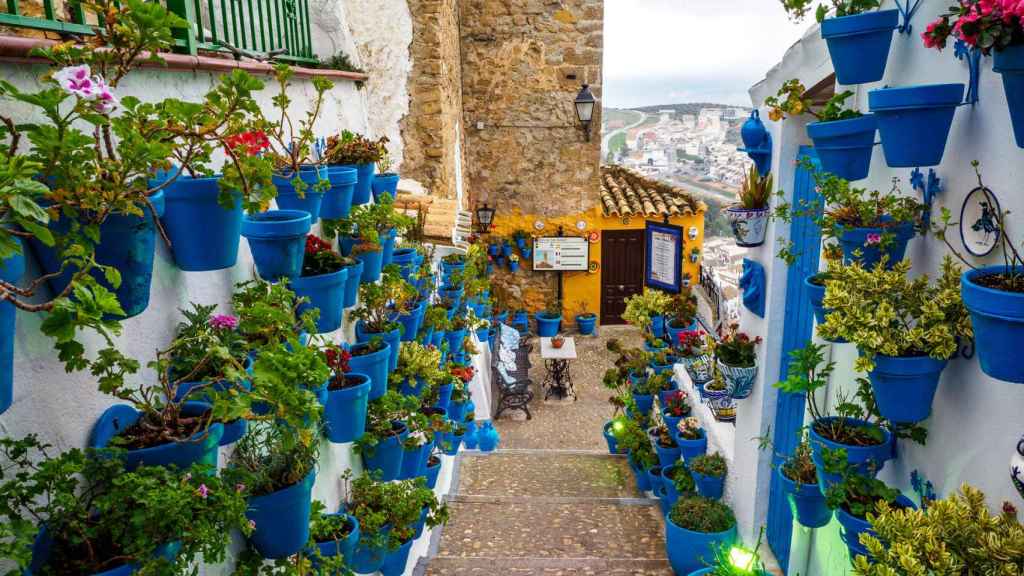 Calle de Iznájar repleta de macetas colgadas.