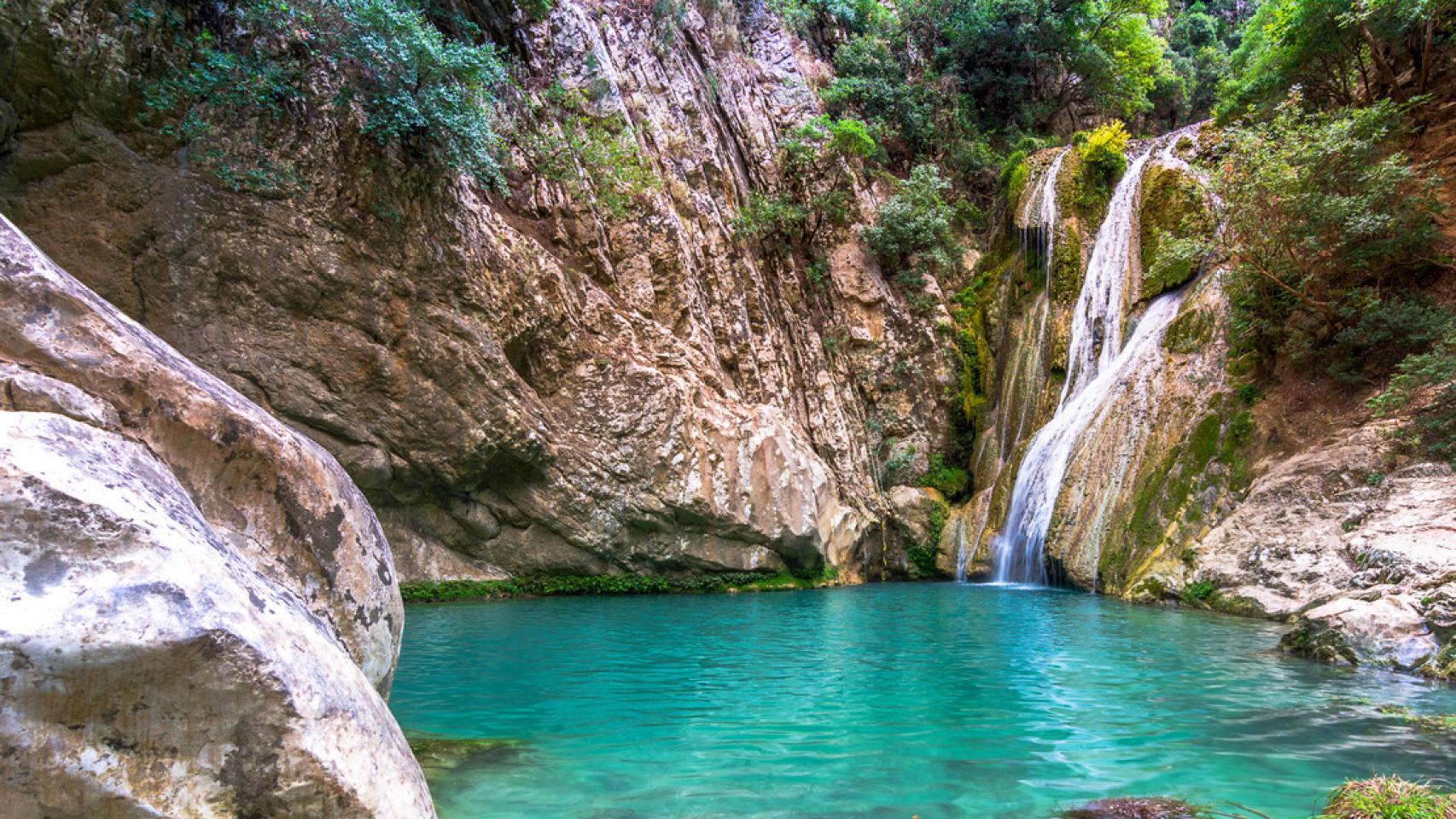 Cascada y piscina natural con aguas cristalinas.