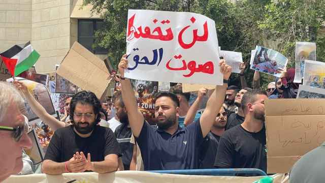 Un estudiante sostiene una pancarta en árabe que reza: No ahogaréis la voz de la verdad.