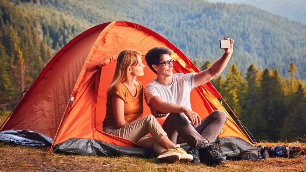 Una pareja usando el móvil en el campo