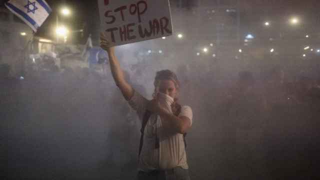 Una mujer sostiene un cartel en una protesta contra la guerra en Gaza, la noche del martes en Tel Aviv.