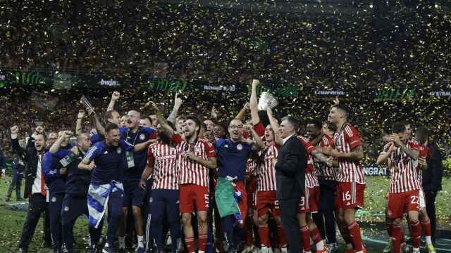 Los jugadores de Olympiacos levantan el título de la Europa League junto a Mendilibar.
