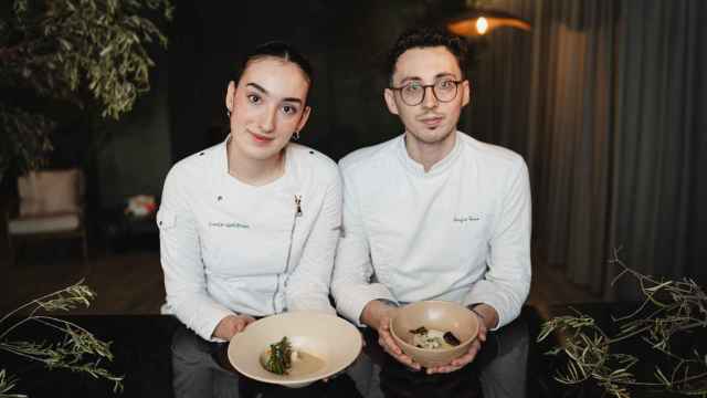 Lucía Gutiérrez y Sergio Vera sujetan dos de sus platos en carta en la barra de su restaurante Lur.