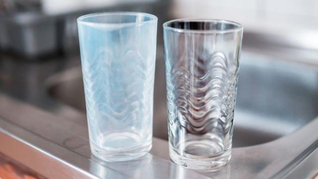 Vasos de cristal antes y después de la limpieza en un fregadero de cocina.