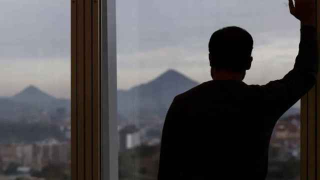 Un hombre mira por la ventana de su oficina en una imagen de archivo. Efe / Miguel Toña
