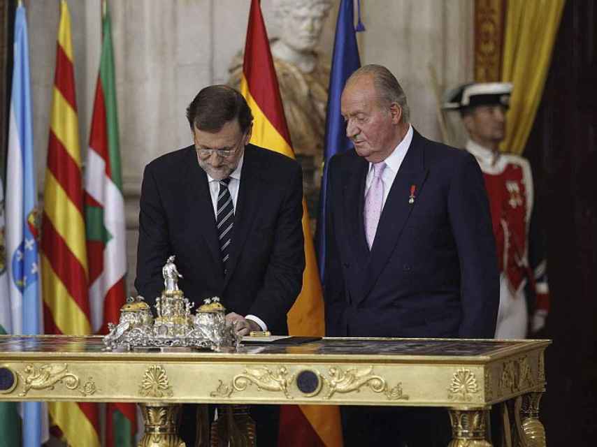 El rey Juan Carlos I,  junto al expresidente Mariano Rajoy, firma su abdicación el 2 de junio de 2014.