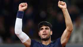 Carlos Alcaraz levanta los brazos tras ganar a Korda en Roland Garros.