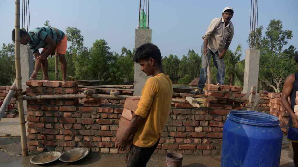 Grupo de trabajadores reconstruyendo una escuela arrasada en 2021.