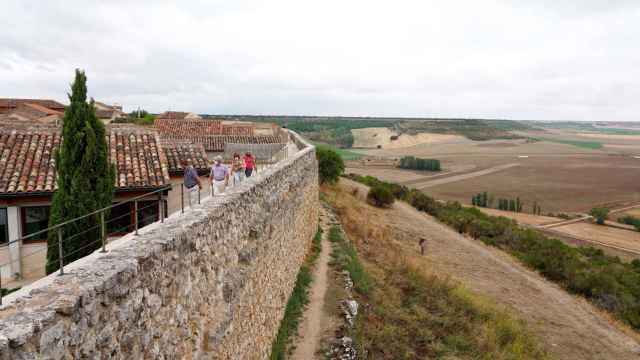 Un grupo de turistas recorre la muralla de la localidad vallisoletana de Urueña