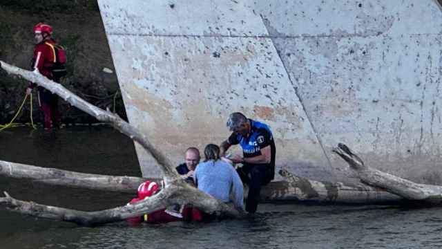 Los Bomberos y la Policía rescatando a una mujer que se había caído al río