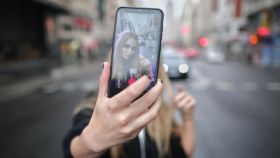 Una joven se hace un 'selfie' con la cámara trasera de su teléfono.