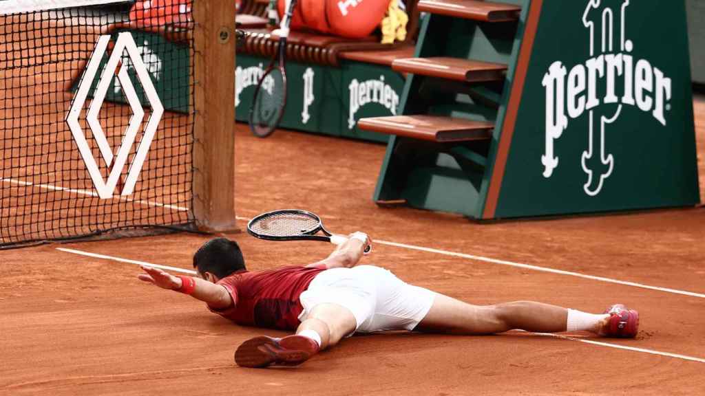 Novak Djokovic, en posición acrobática en el suelo.