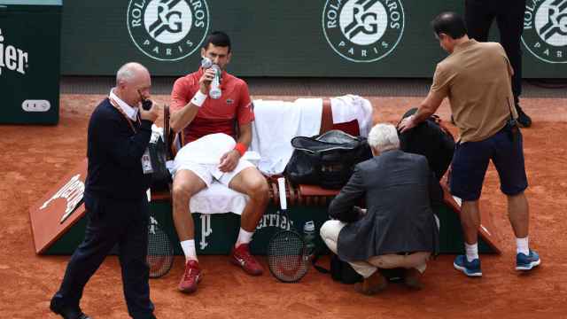 Novak Djokovic, atendido por el fisio tras su percance en Roland Garros.