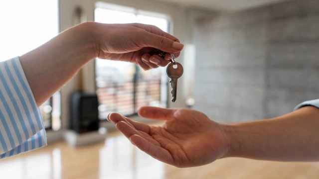Agente inmobiliario entregando las llaves de su nueva casa a un hombre.