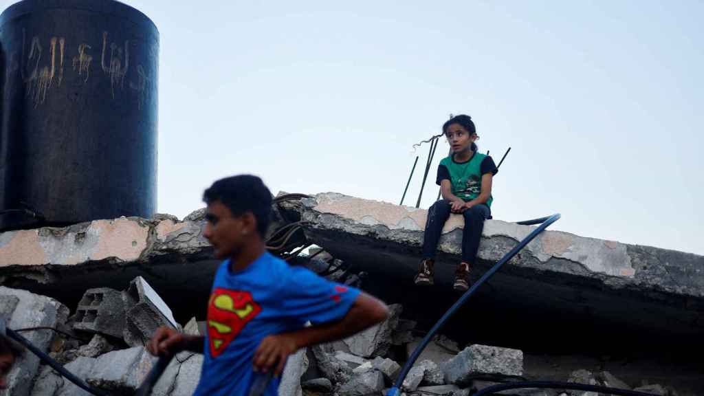 Dos niños palestinos sobre los escombros en una ciudad del sur de Gaza.