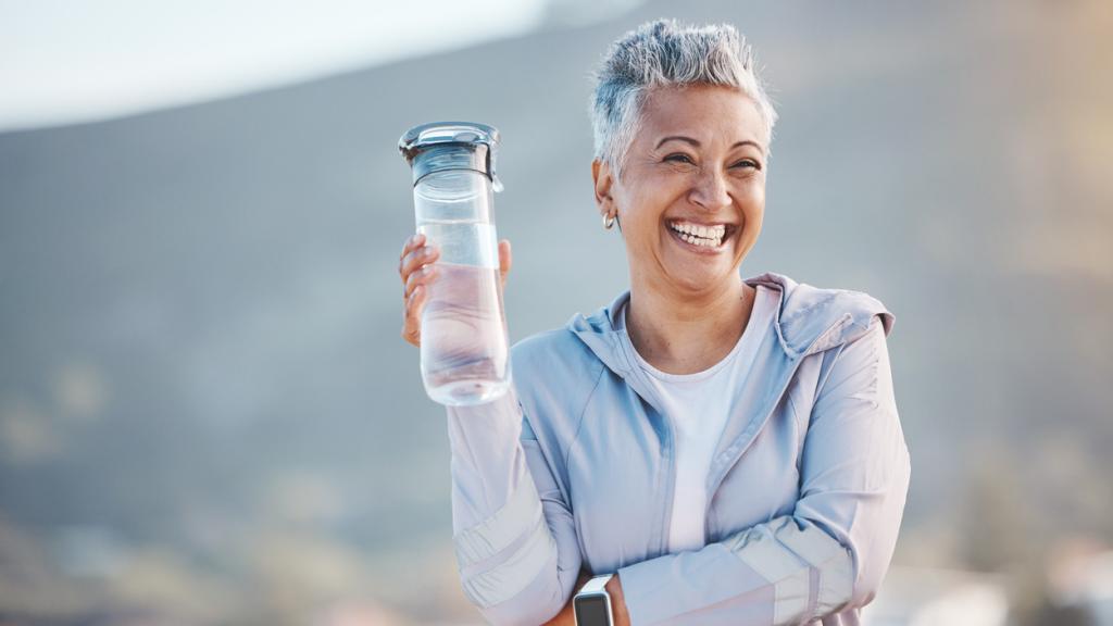 Mujer con una botella de agua tras realizar ejercicio.