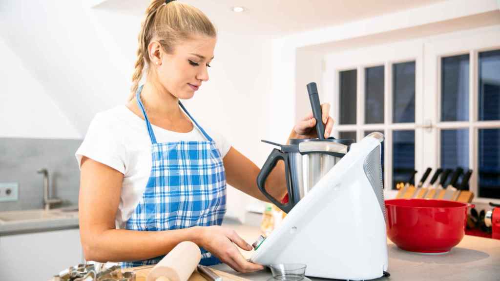 Una persona maneja un robot de cocina sobre una encimera