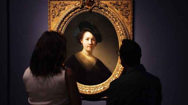 Unos visitantes observan 'Retrato de joven con bonete negro y pendientes de perla', de Rembrandt (1632)