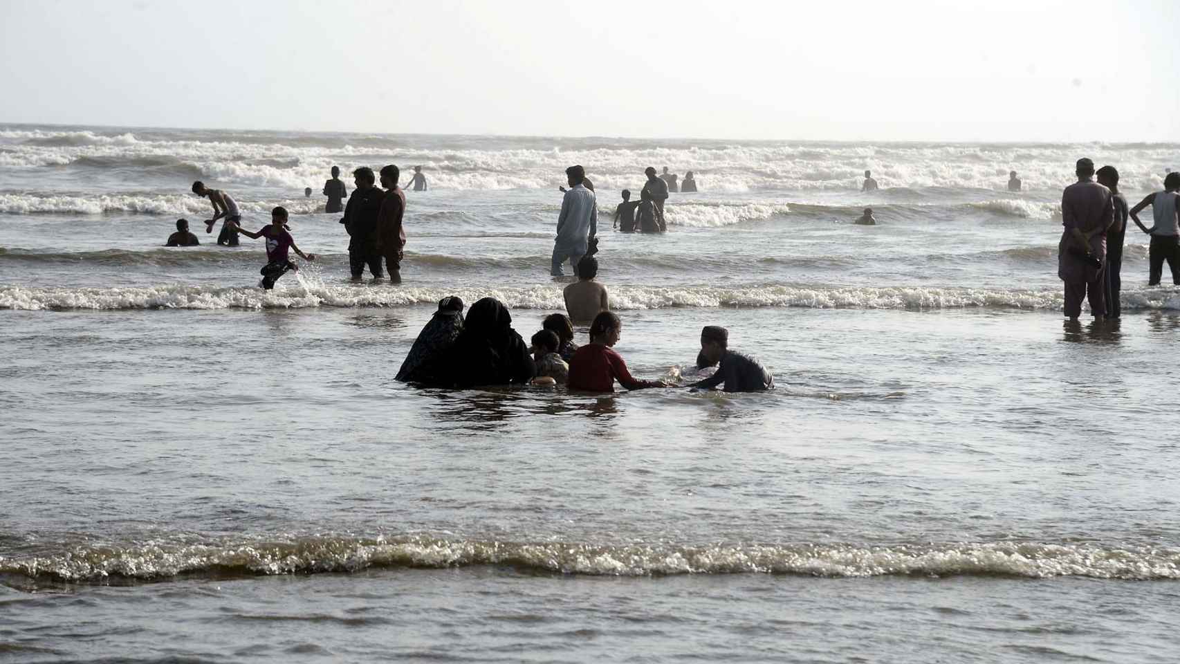 Varias personas disfrutan de un día en la playa en Pakistán, donde las temperaturas superaron los 50 ºC en mayo.