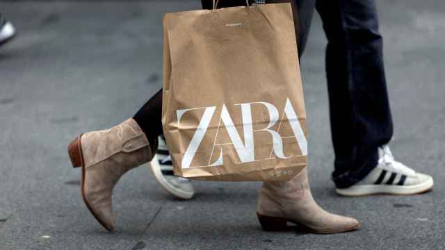 Una persona lleva una bolsa de Zara, una de las marcas propiedad de Inditex.