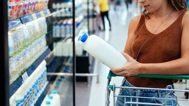 Mujer comprando leche en el supermercado.
